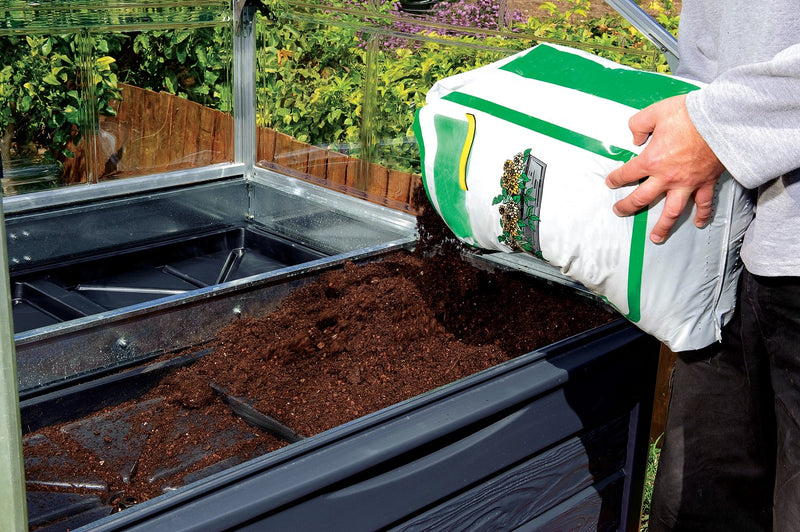 Adding compost to the Plant Inn elevated garden bed